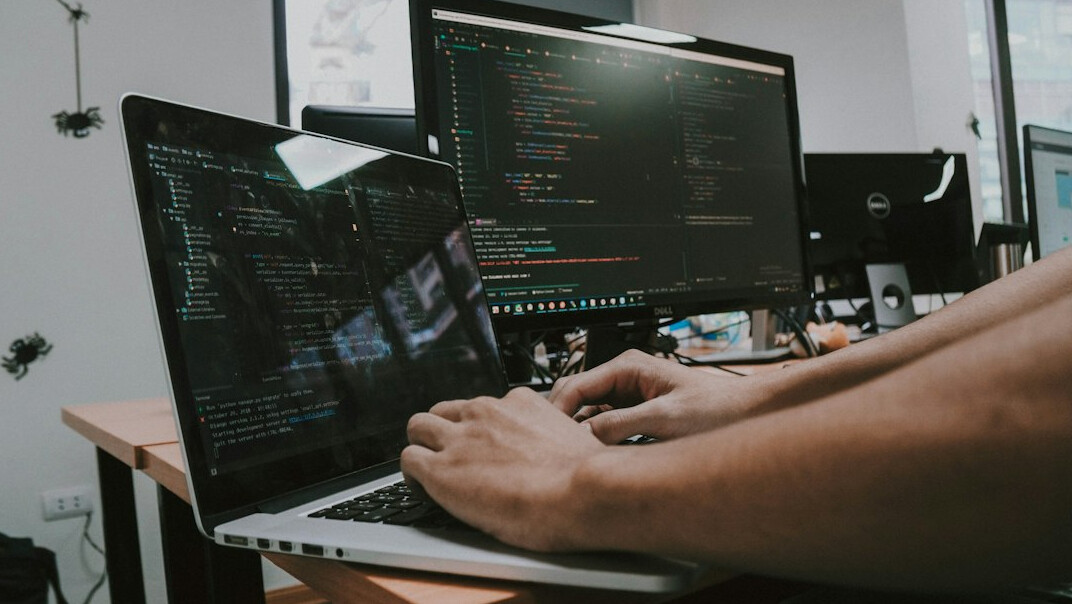 person coding on laptop