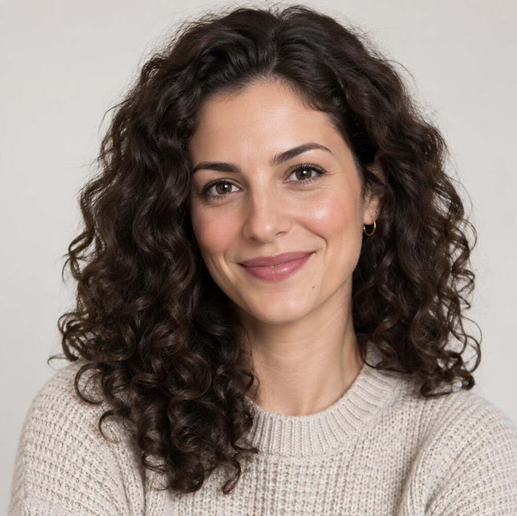 Studio portrait of a young Croatian woman with curly hair smiling